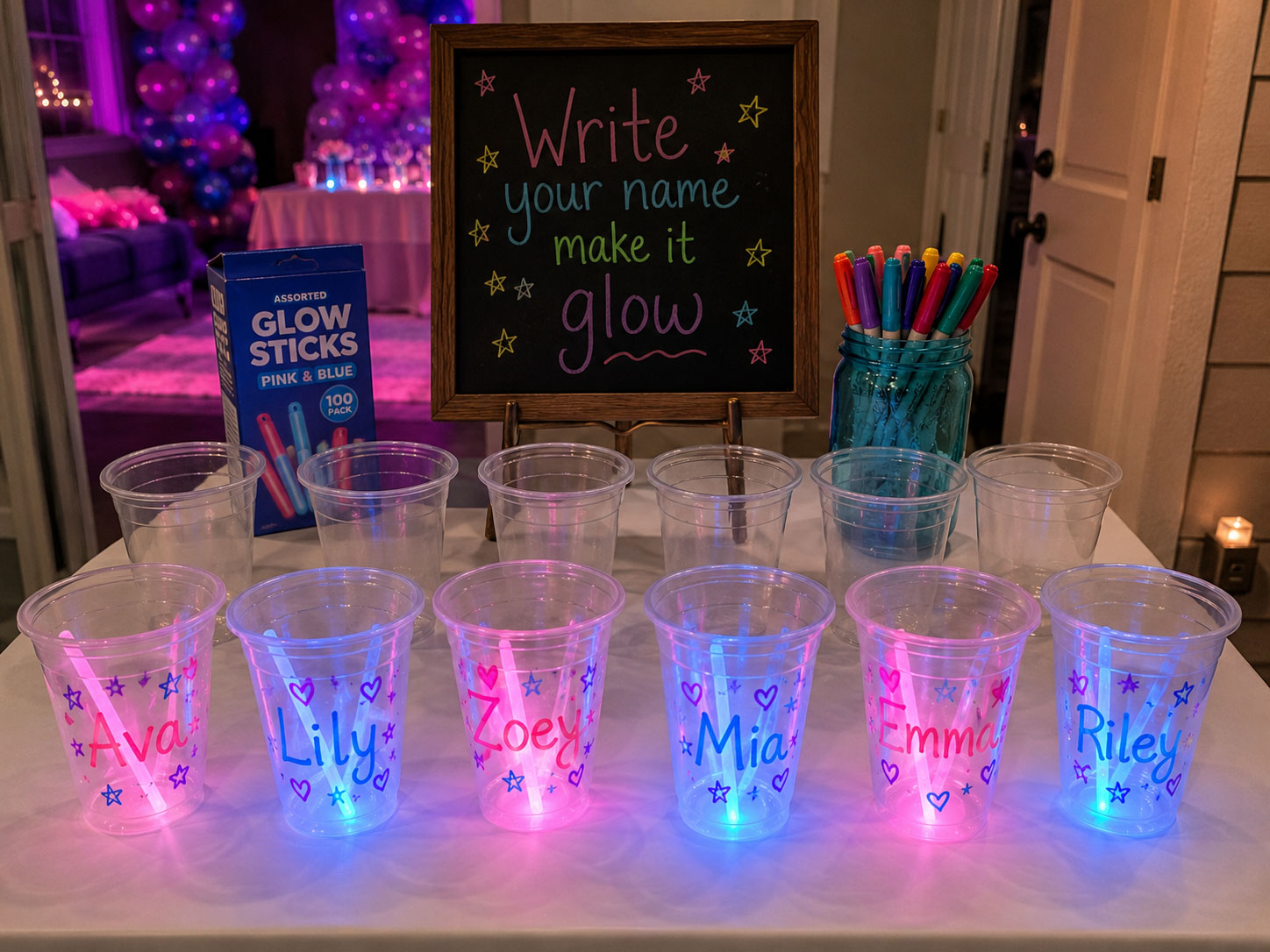 Personalized glow cup activity station at a birthday party with decorated glowing cups and markers for kids