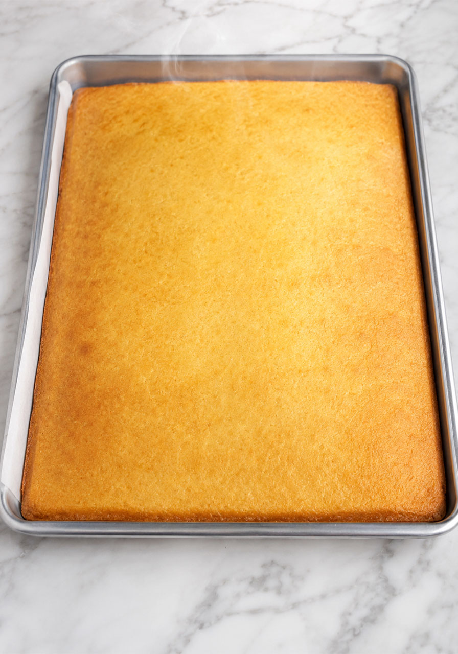 Perfectly baked golden vanilla sheet cake in half sheet pan for petit fours recipe