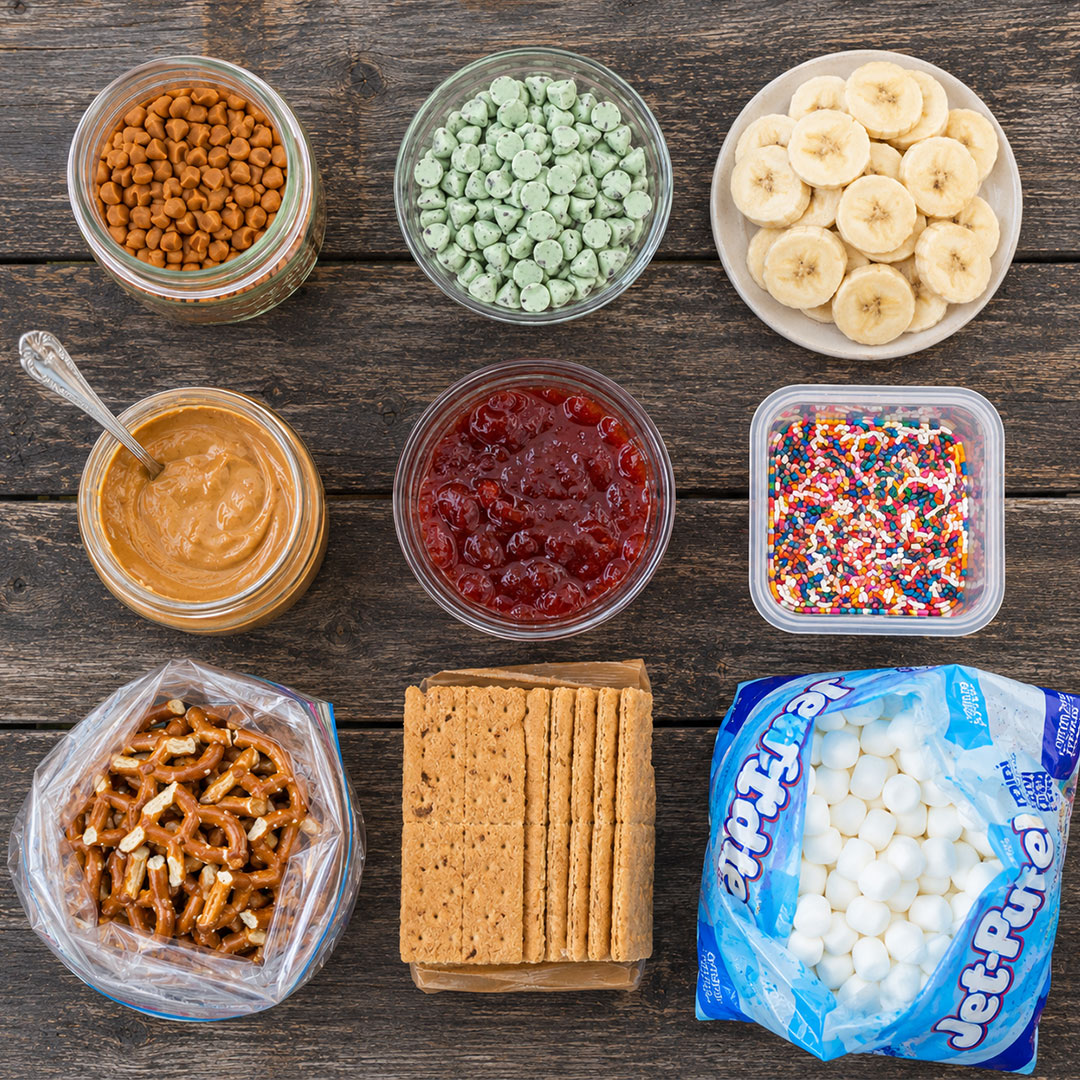 S'mores nacho bar toppings station with caramel, banana, pretzels, and sprinkles