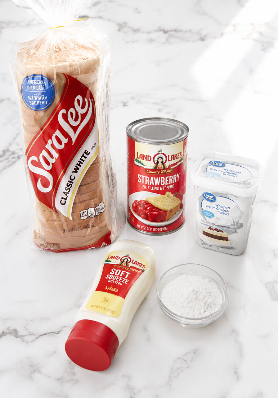 5 ingredients for strawberry cheesecake pudgy pie: white bread, strawberry pie filling, whipped cream cheese, butter, and powdered sugar