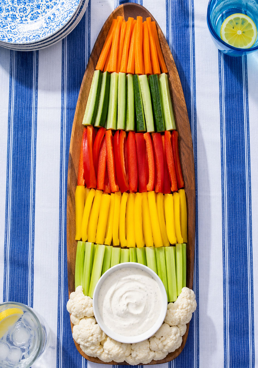 Vegetable platter arranged in the shape of a surfboard with ranch dip