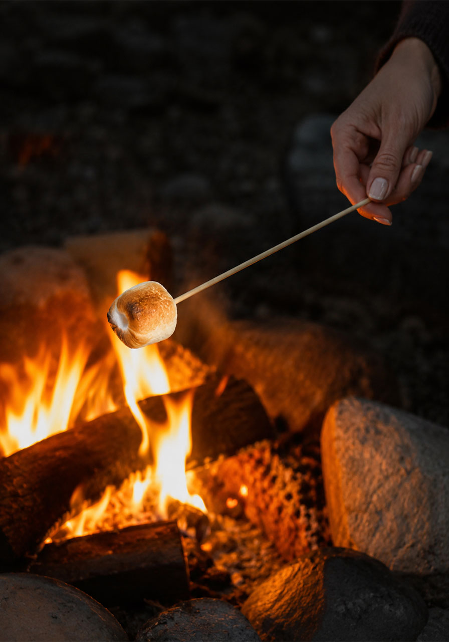 Toasting a marshmallow over a campfire flame for Oreo s'mores