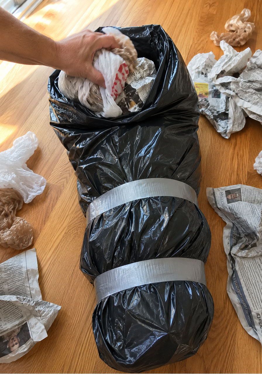 Stuffing and duct-taping the leg section of a DIY Halloween corpse prop