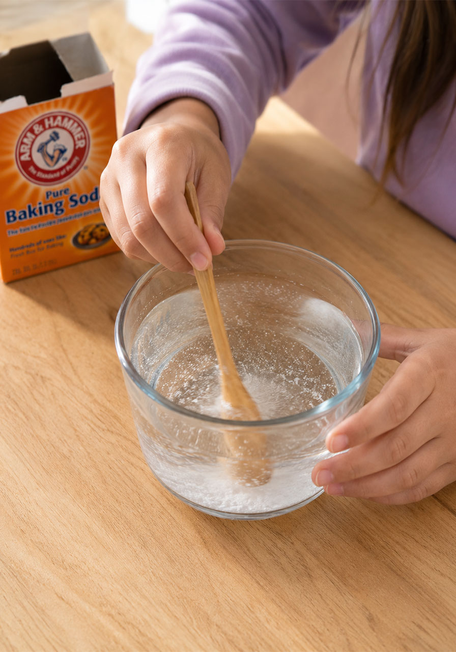 Mixing baking soda and warm water until the solution turns clear