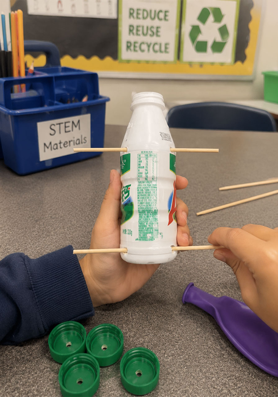 Poking a wooden skewer through the bottle to create axles for the balloon car STEM activity