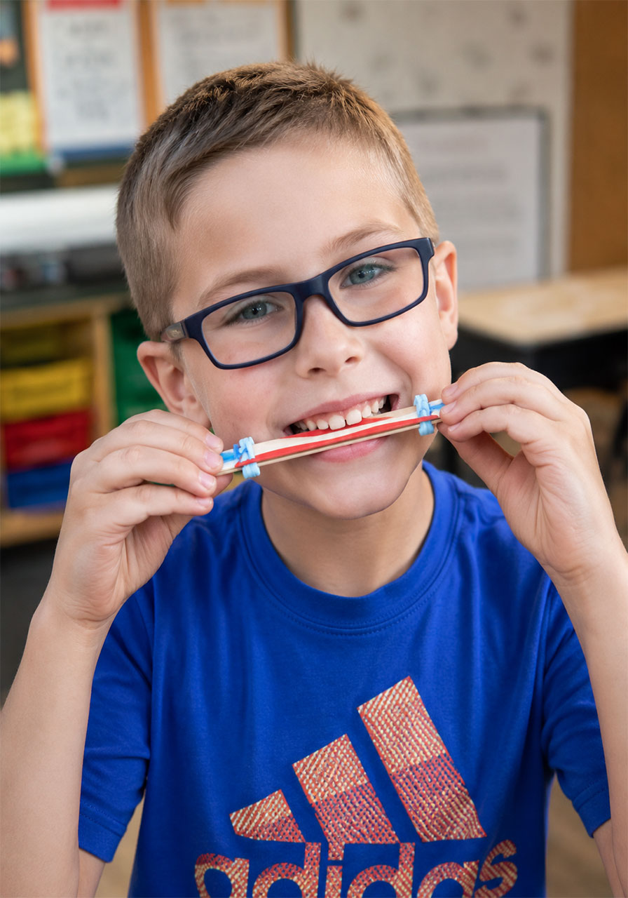 Sliding the straws to change the pitch on a craft stick harmonica