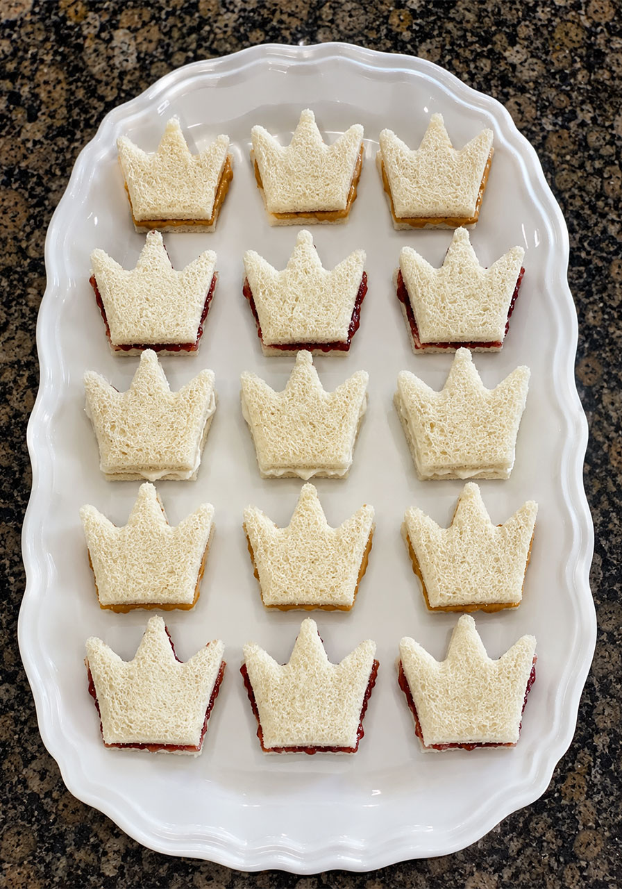 Crown-shaped peanut butter and jelly finger sandwiches for a princess birthday party food table