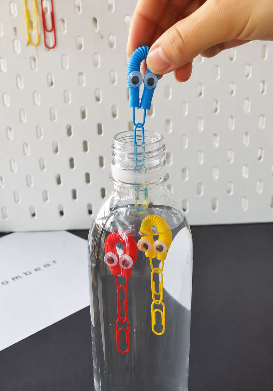 Inserting octopus divers into water bottle for STEM float experiment
