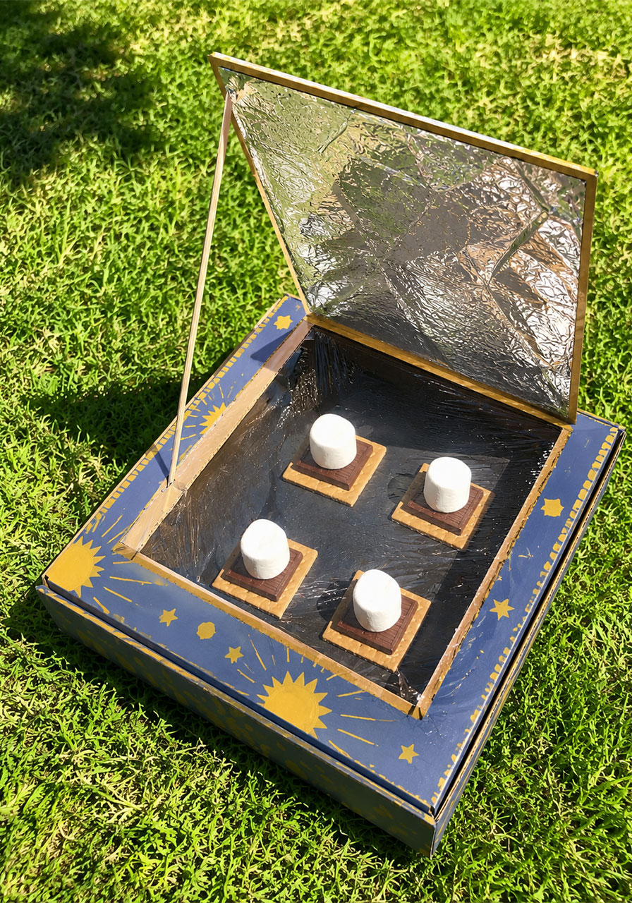 DIY solar oven made from a pizza box with s'mores melting in the sun