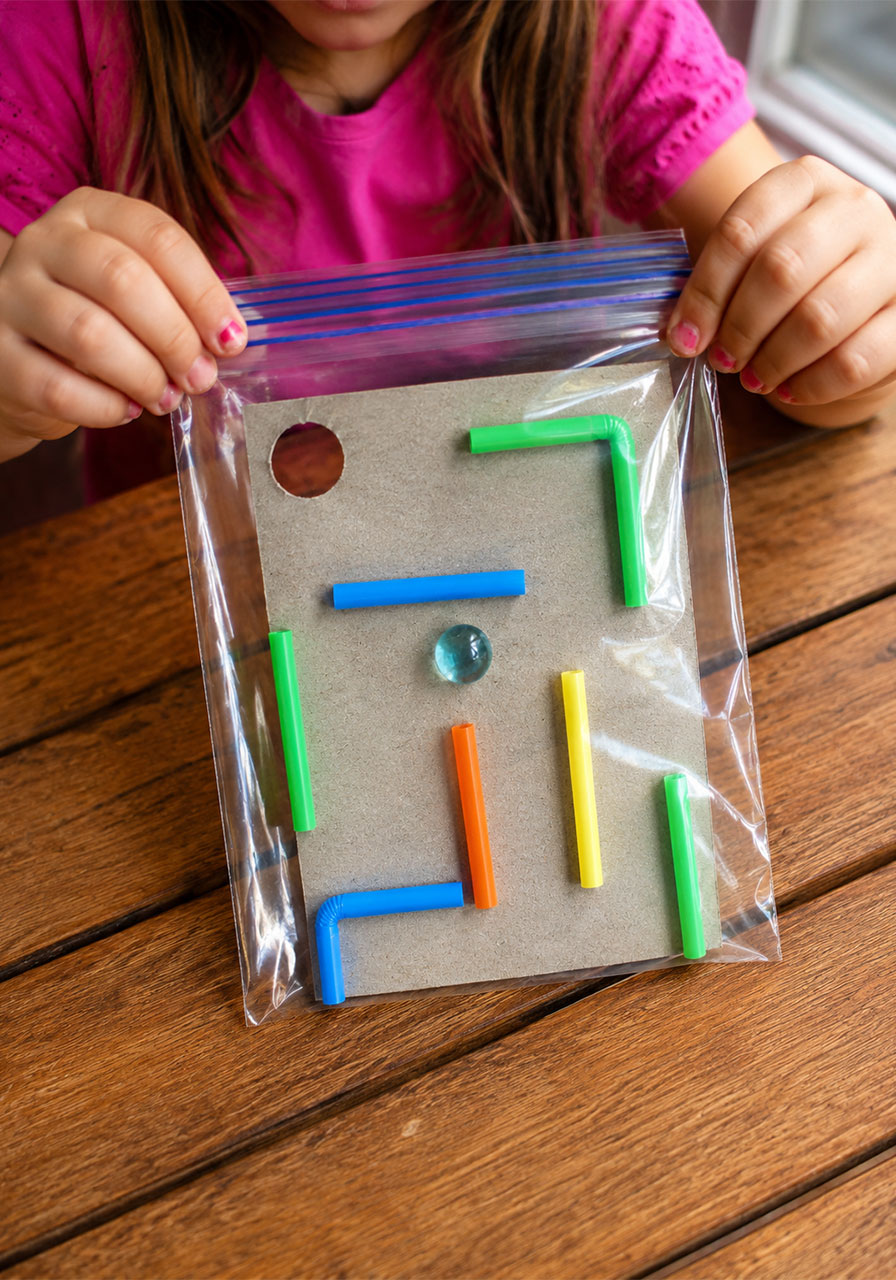 Elementary kid playing easy STEM maze in a baggie activity