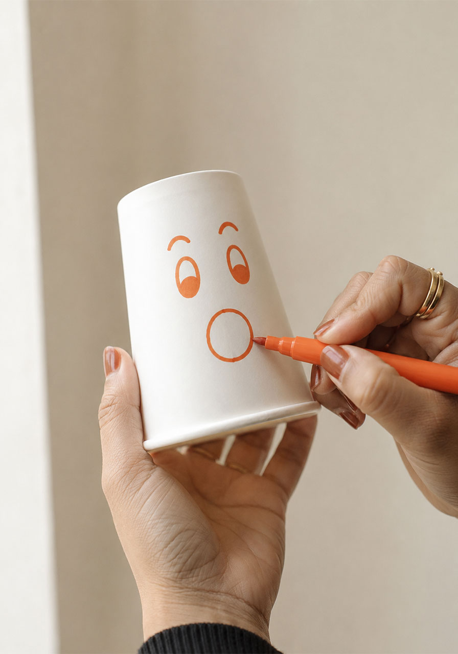 Drawing a cartoon face on a paper cup for the DIY smoke ring craft