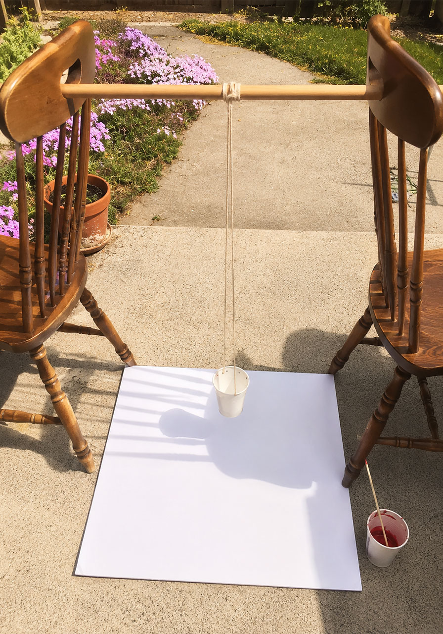 Easy pendulum painting for kids: complete DIY setup with chairs, broom handle, and hanging paint cup