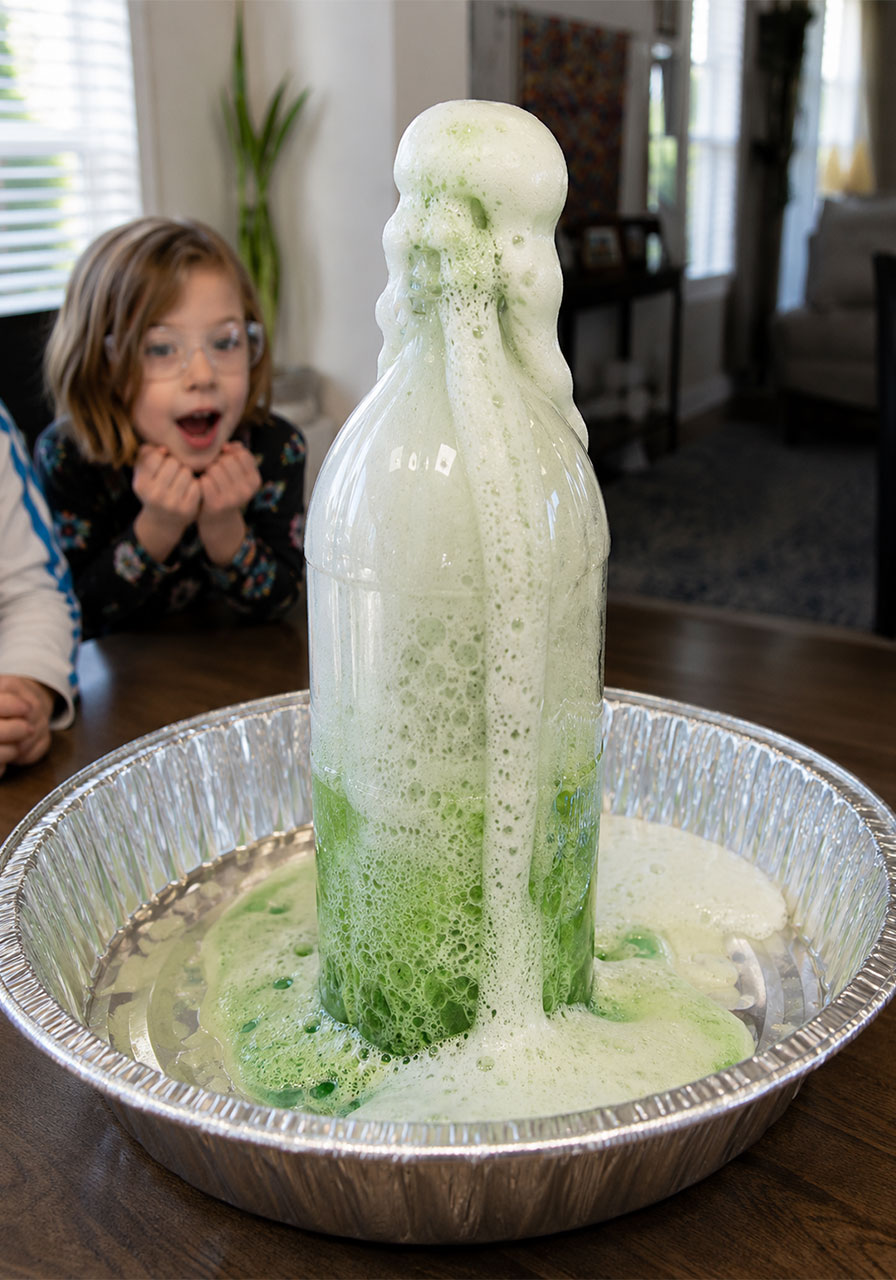 Elephant toothpaste foam rising out of bottle during chemical reaction