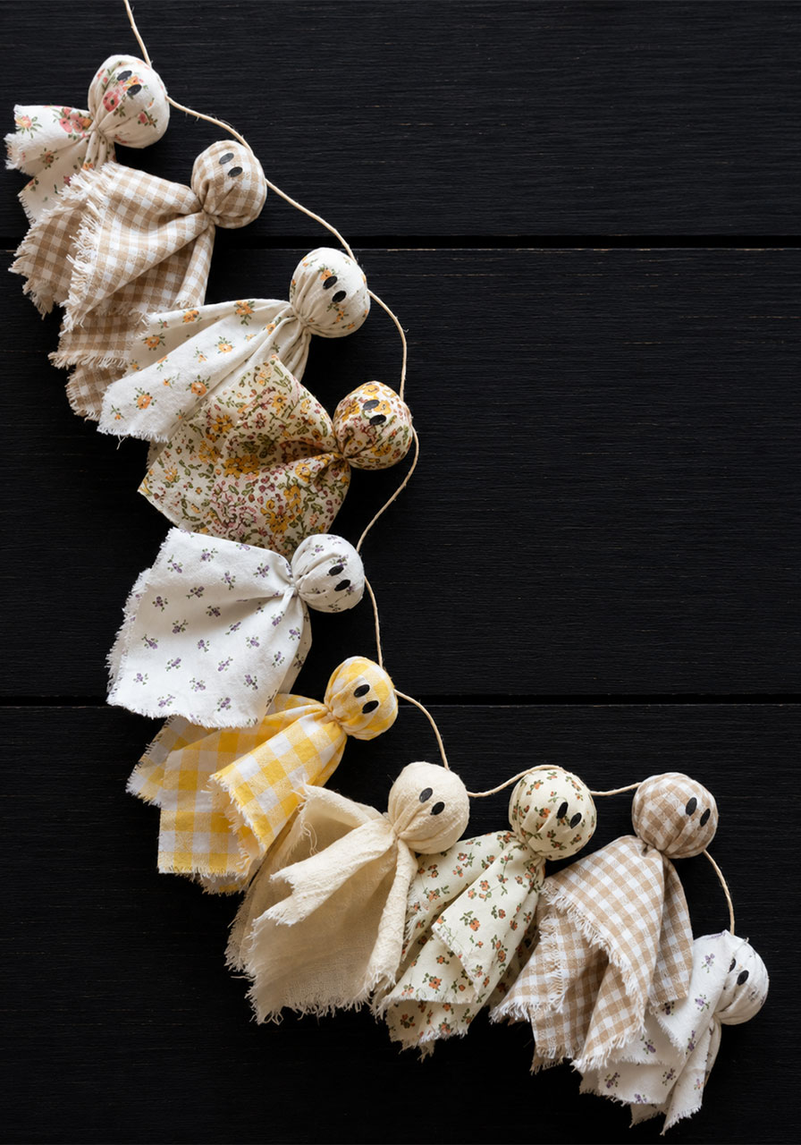 Finished handmade fabric ghost garland with ten ghosts laid flat