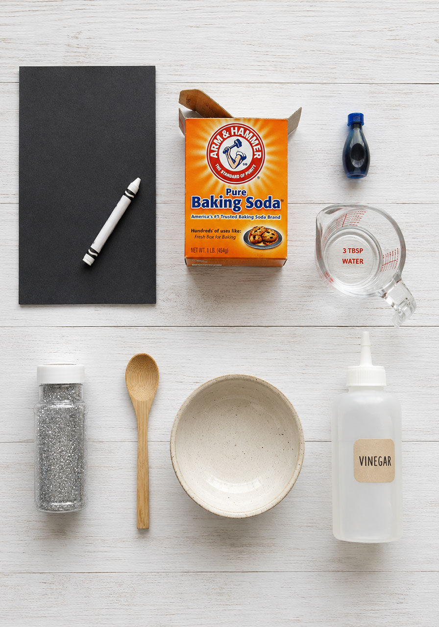 Materials needed for DIY fizzing moon art project including baking soda vinegar and construction paper