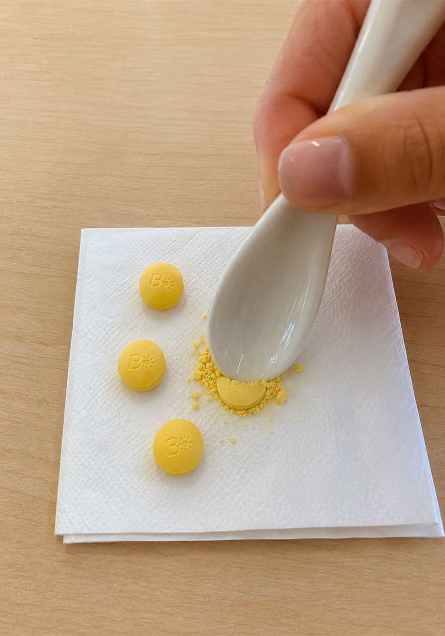 Crushing a vitamin B tablet into powder with a spoon for the meteor shower experiment