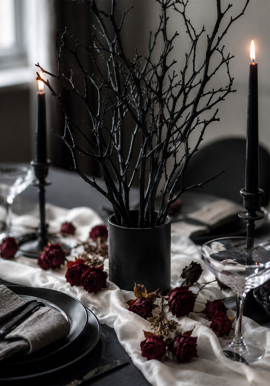Black painted branch centerpiece with dried roses for gothic Halloween table