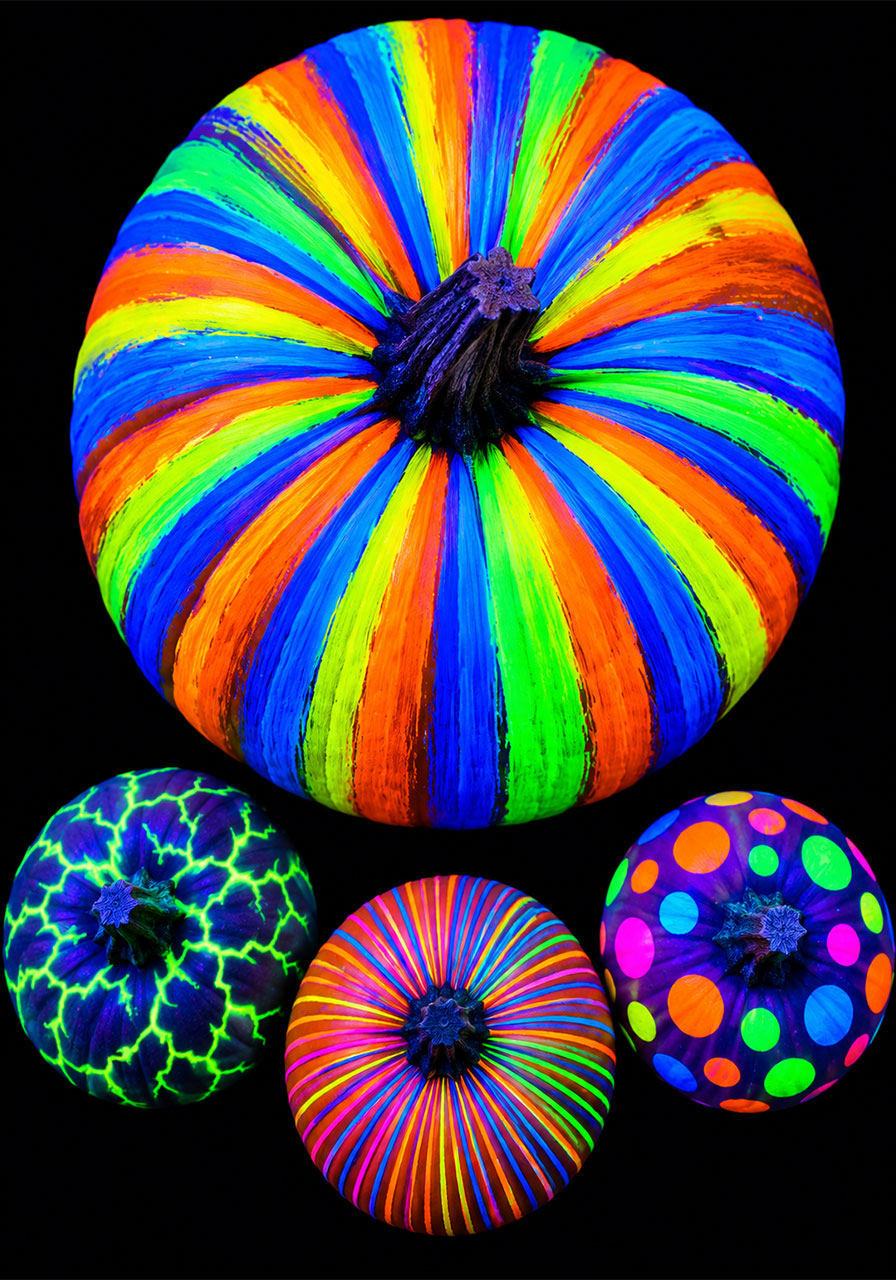 Glow-in-the-dark painted pumpkins glowing neon colors under blacklight for Halloween