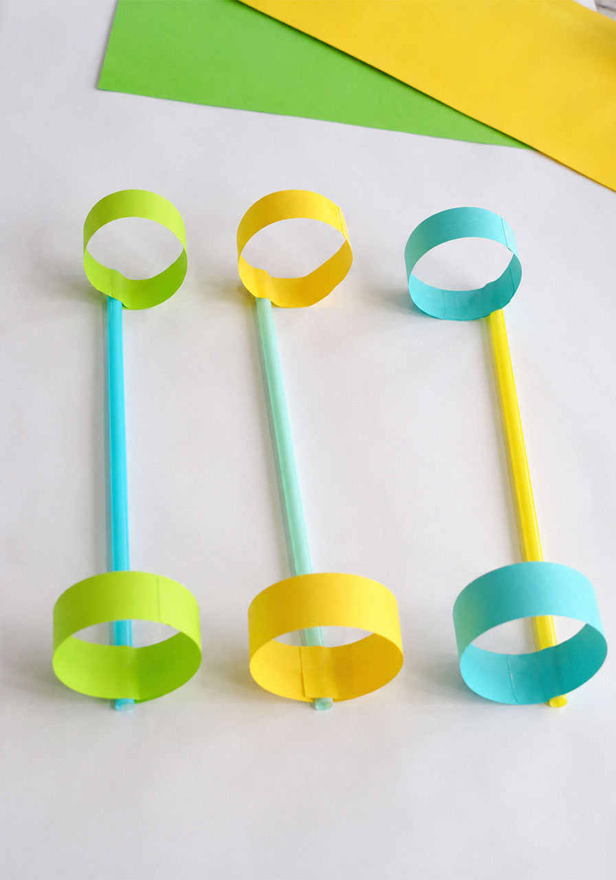 Three finished hoop glider paper planes made with straws and paper loops, an easy STEM activity for kids