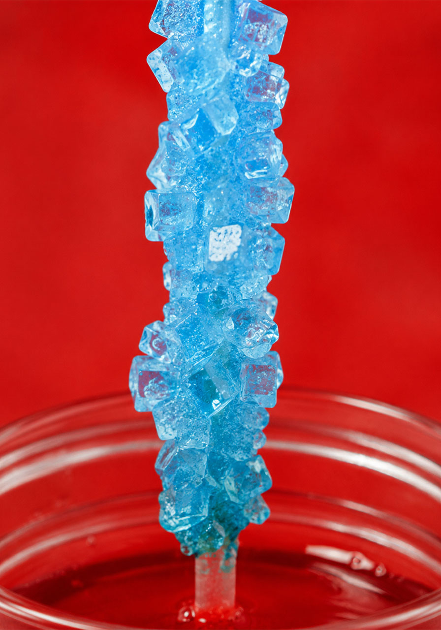 Close-up of sugar crystals forming on a stick in rock candy jar