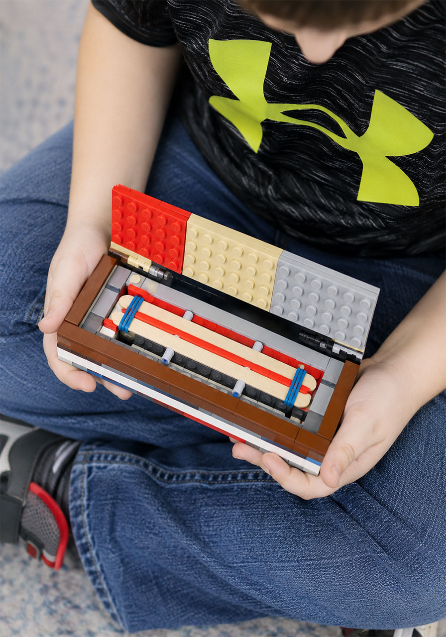 Child-built LEGO storage case for a craft stick harmonica