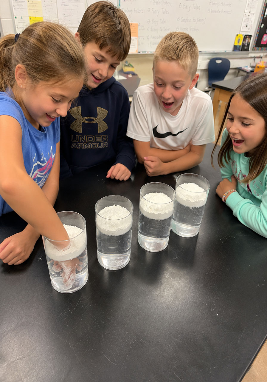 Elementary students trying the Magic Powder Shield experiment together as a classroom STEM activity