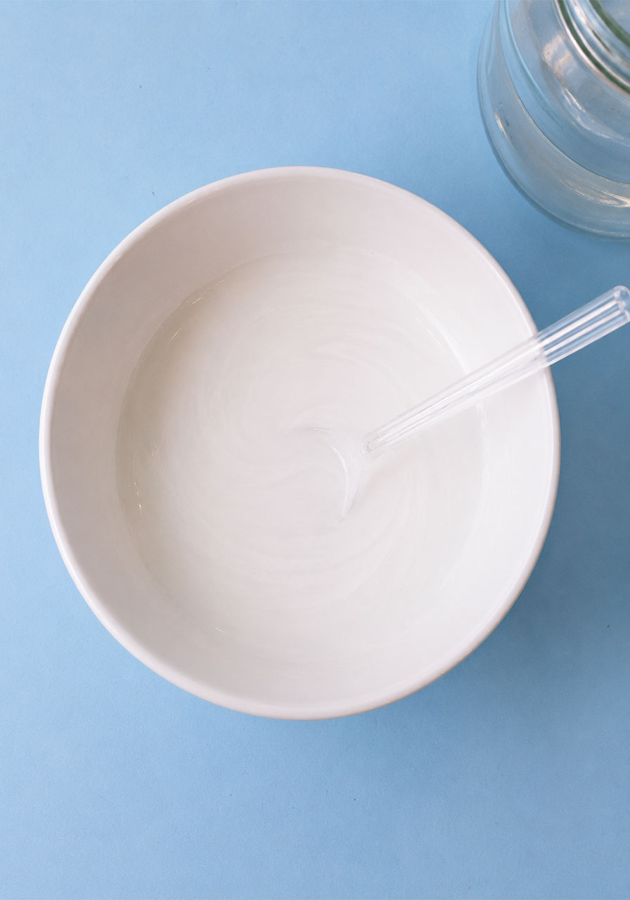 Bowl of white paint and water mixture for snowstorm in a jar experiment