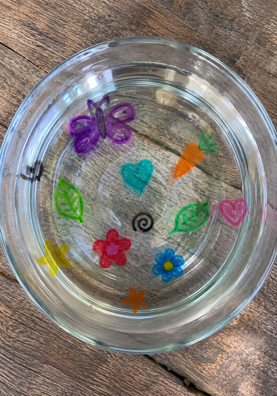 Several colorful dry erase drawings floating together on water