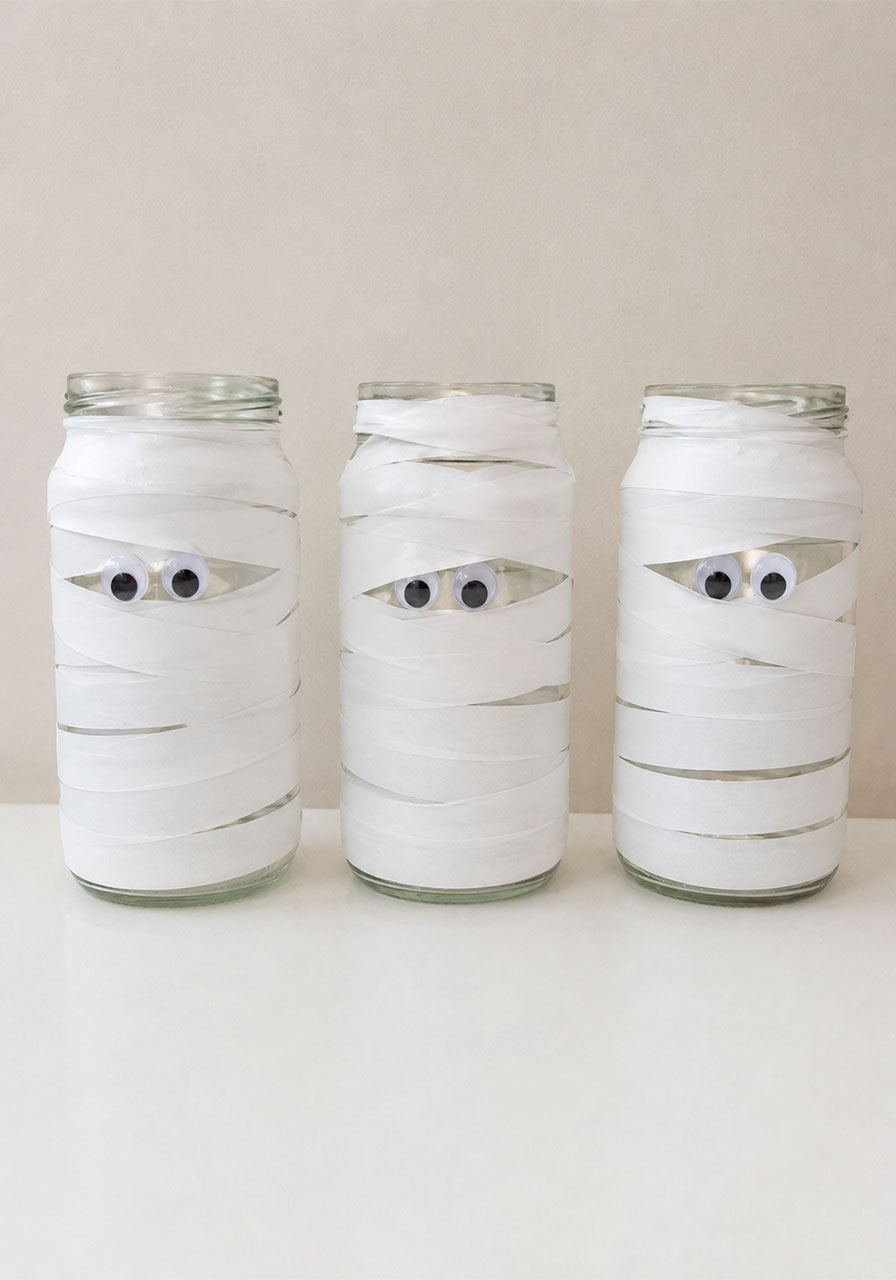 Three finished mummy jar lanterns wrapped in tape before adding LED candles