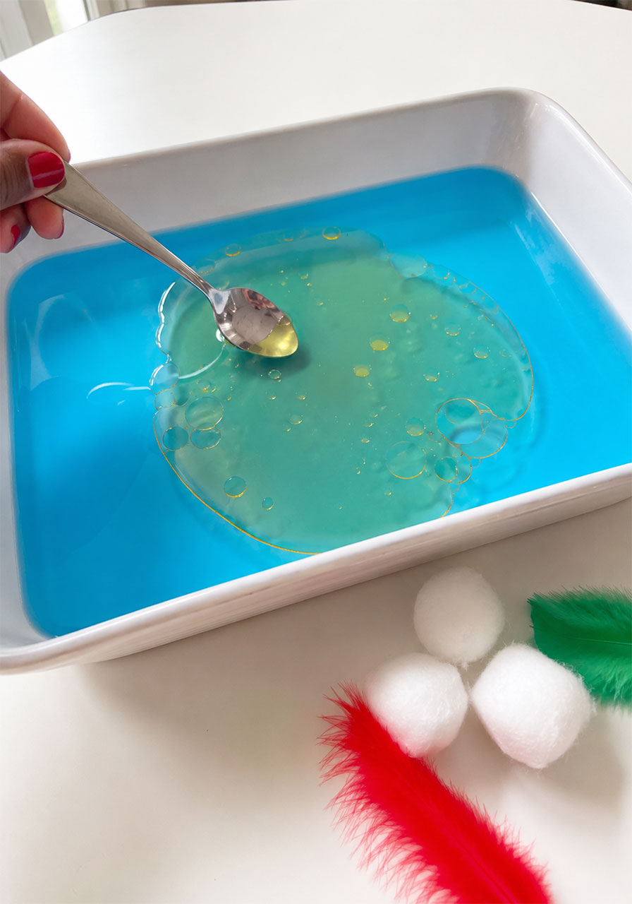 Oil spill clean-up experiment showing oil floating on blue water for an Earth Day STEM activity for kids