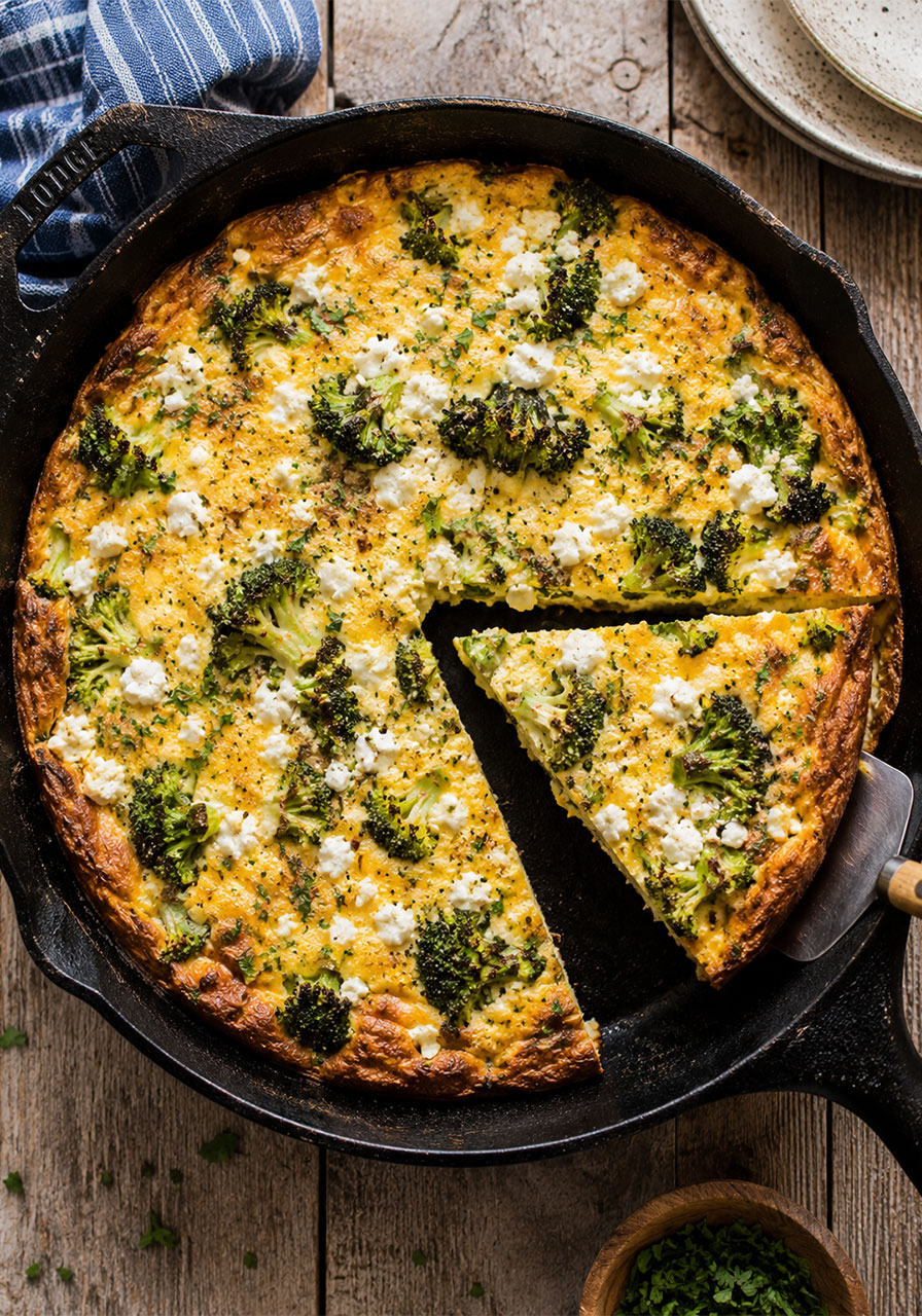 One pot camping meal: cast iron frittata with broccoli and feta cheese sliced into wedges