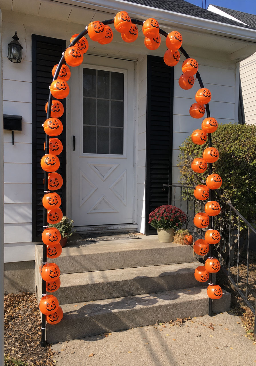Outdoor Halloween decoration arch built from orange plastic pumpkin pails