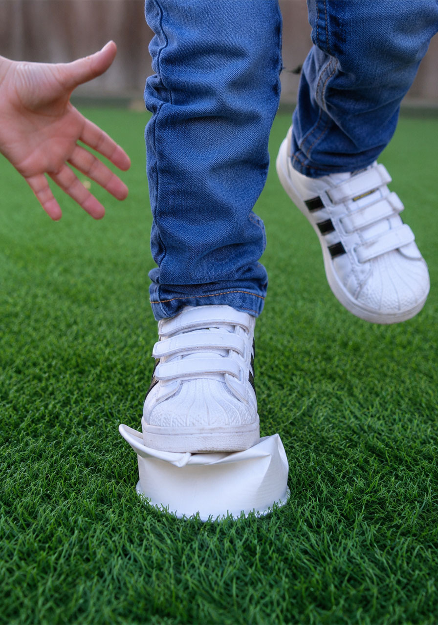 Single paper cup collapsing when a child steps on it before the STEM experiment
