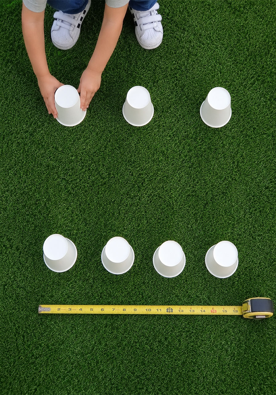 Paper cups spaced evenly in a grid pattern for the stand-on-a-cup STEM challenge