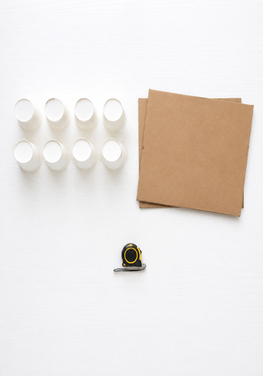 Materials needed for the paper cup STEM activity including cups and cardboard
