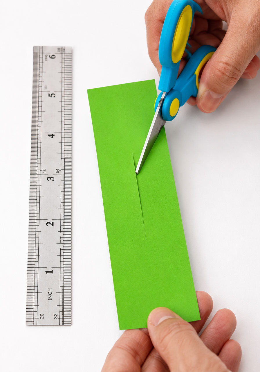 Cutting a 3-inch center slit into cardstock to make paper helicopter blades