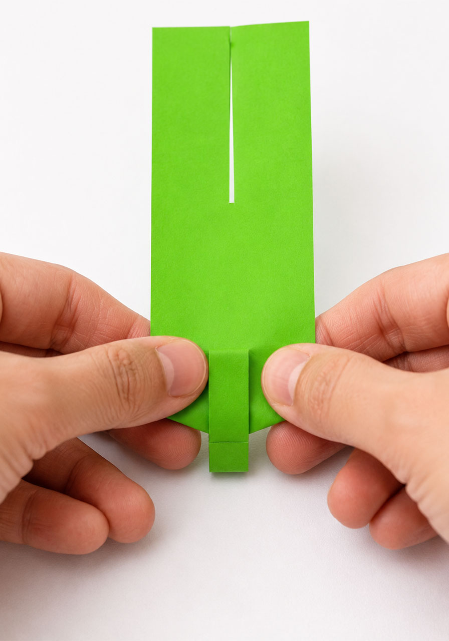 Folding the base of a paper helicopter to create the spinning stem