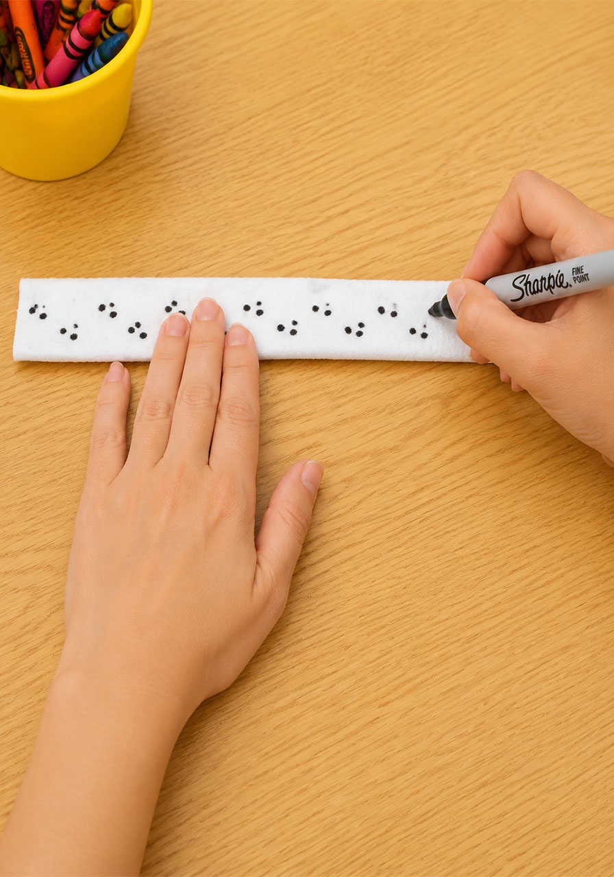 Drawing permanent marker dot pattern on paper towel tube for worm texture