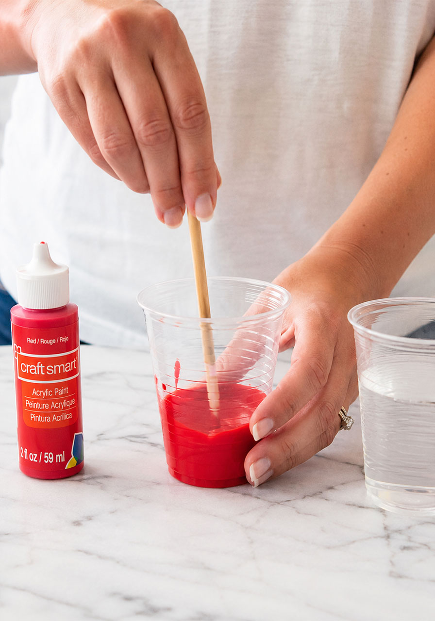 Mixing thin, runny acrylic paint and water for pendulum painting consistency