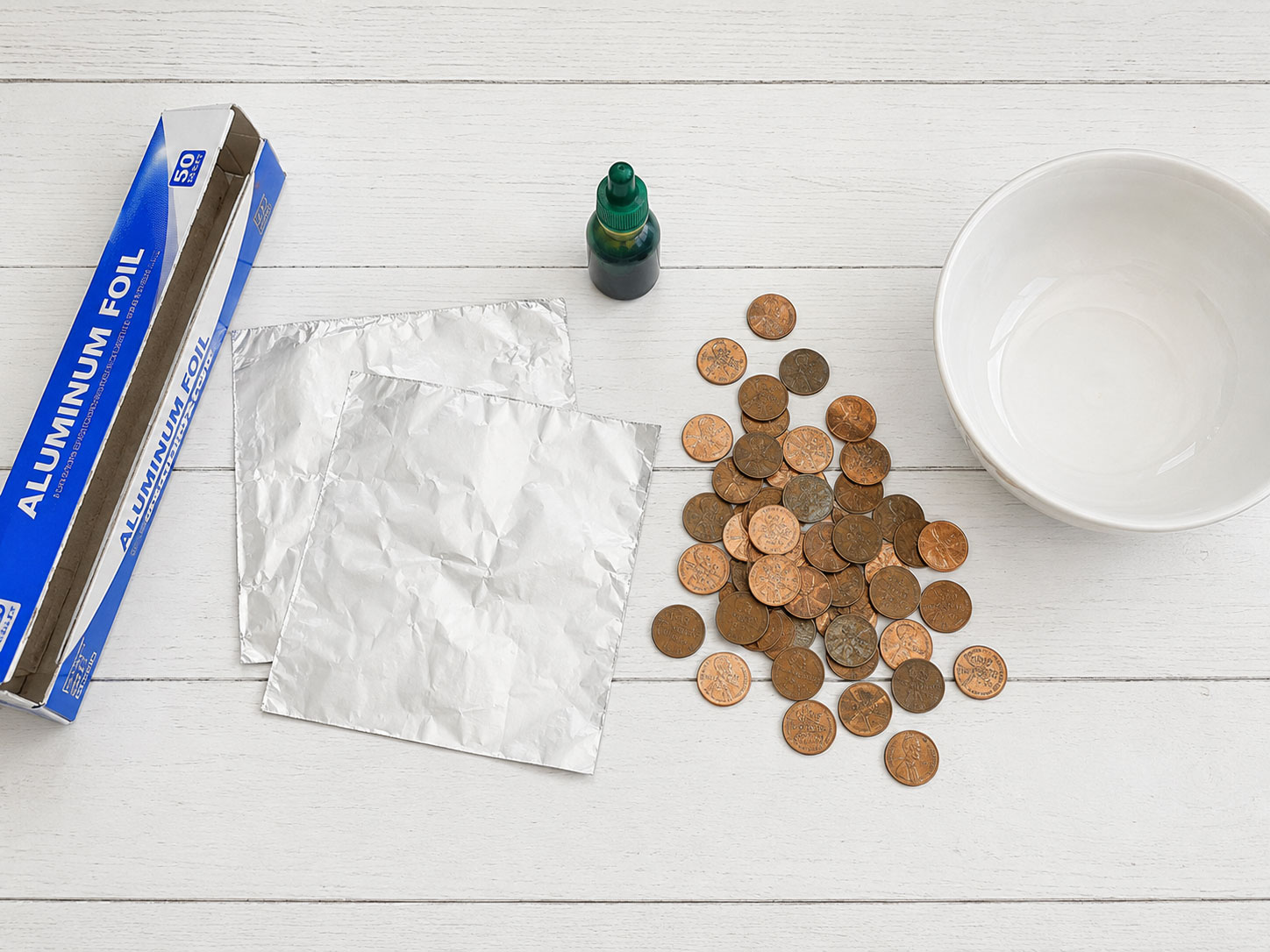Materials needed for the penny boat challenge including foil, pennies, food coloring, and a bowl of water