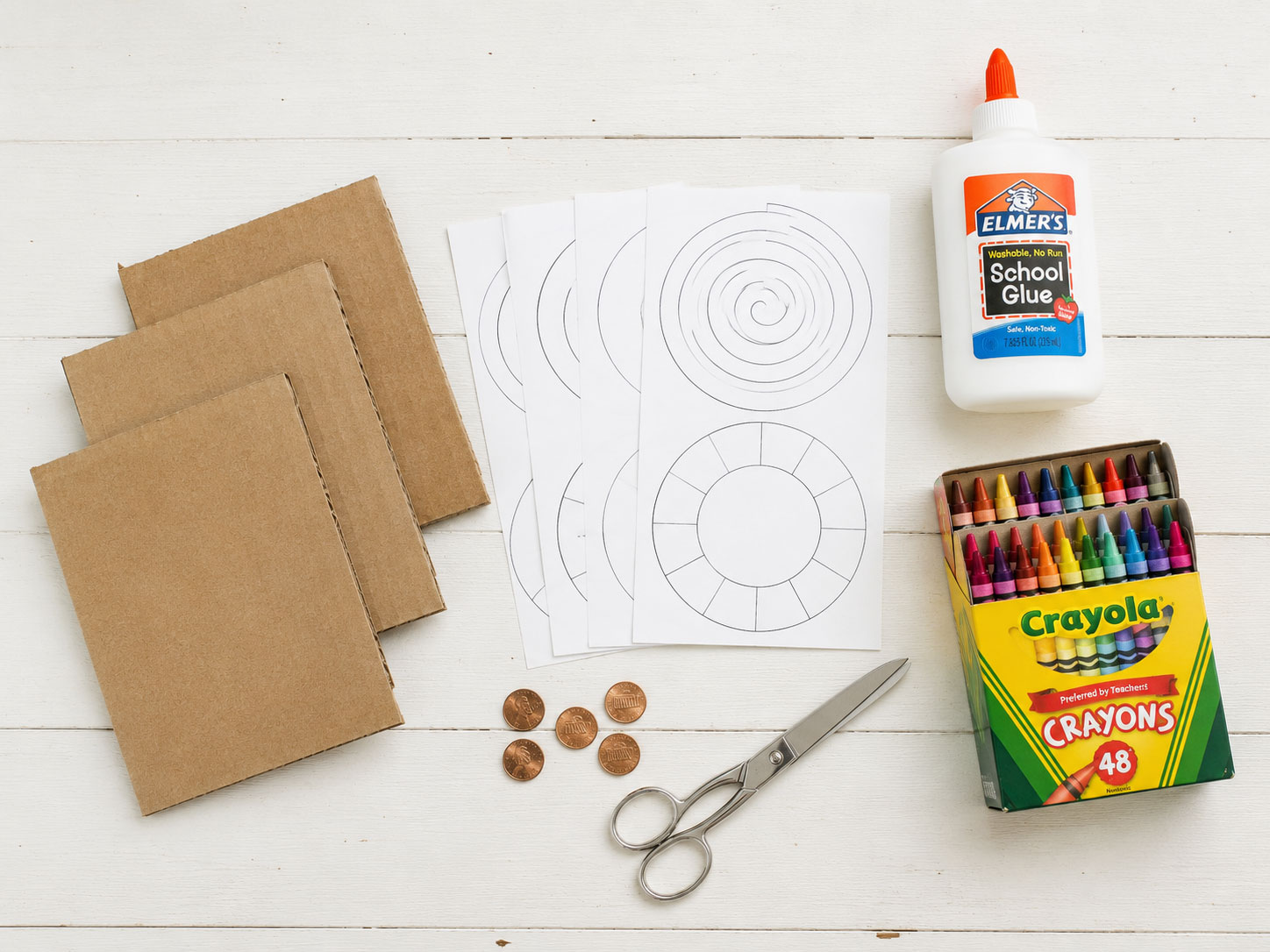 Supplies needed to make penny spinners including cardboard, templates, pennies, and crayons