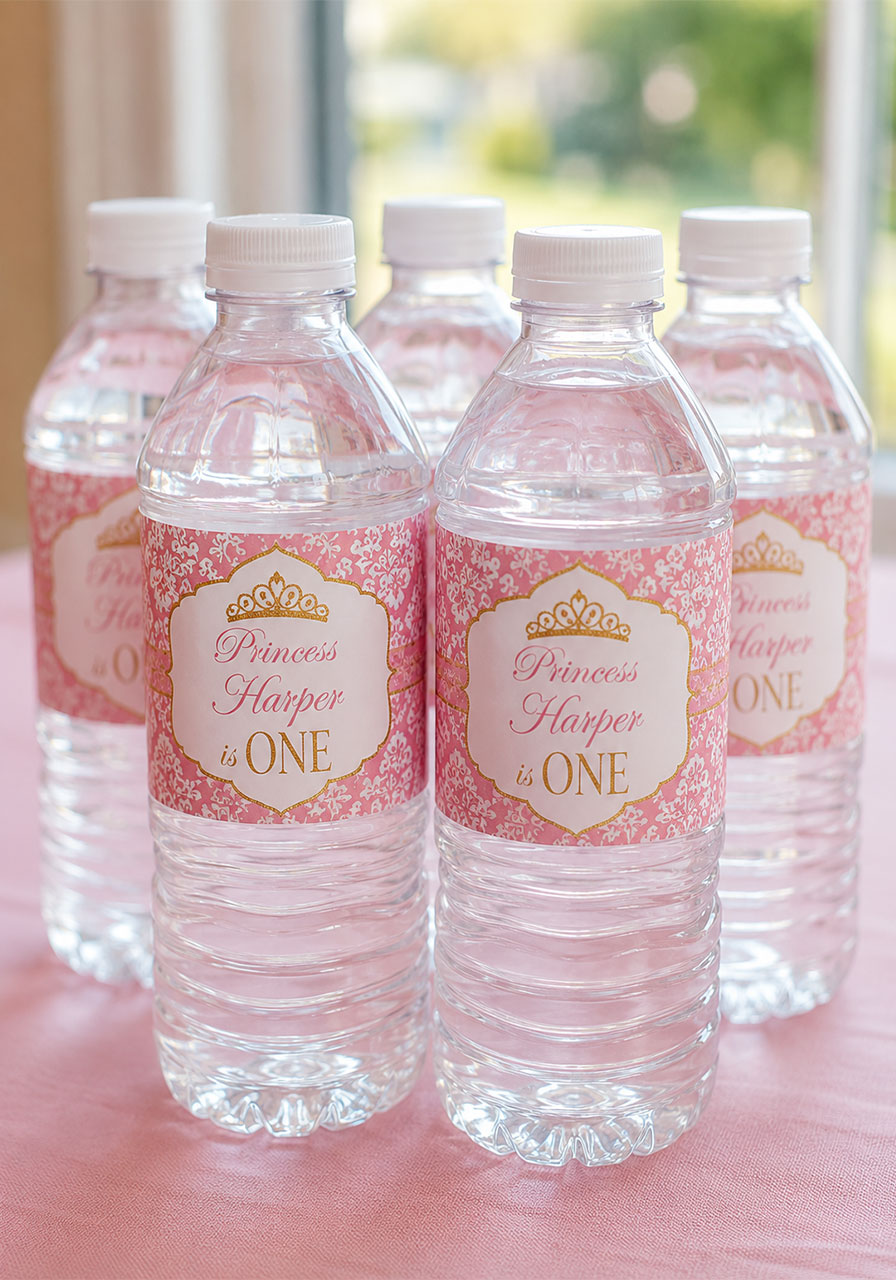 Personalized pink and gold princess water bottle labels for a first birthday party