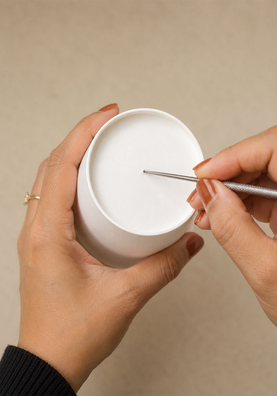 Poking the top air hole in the paper cup for the smoke ring trick