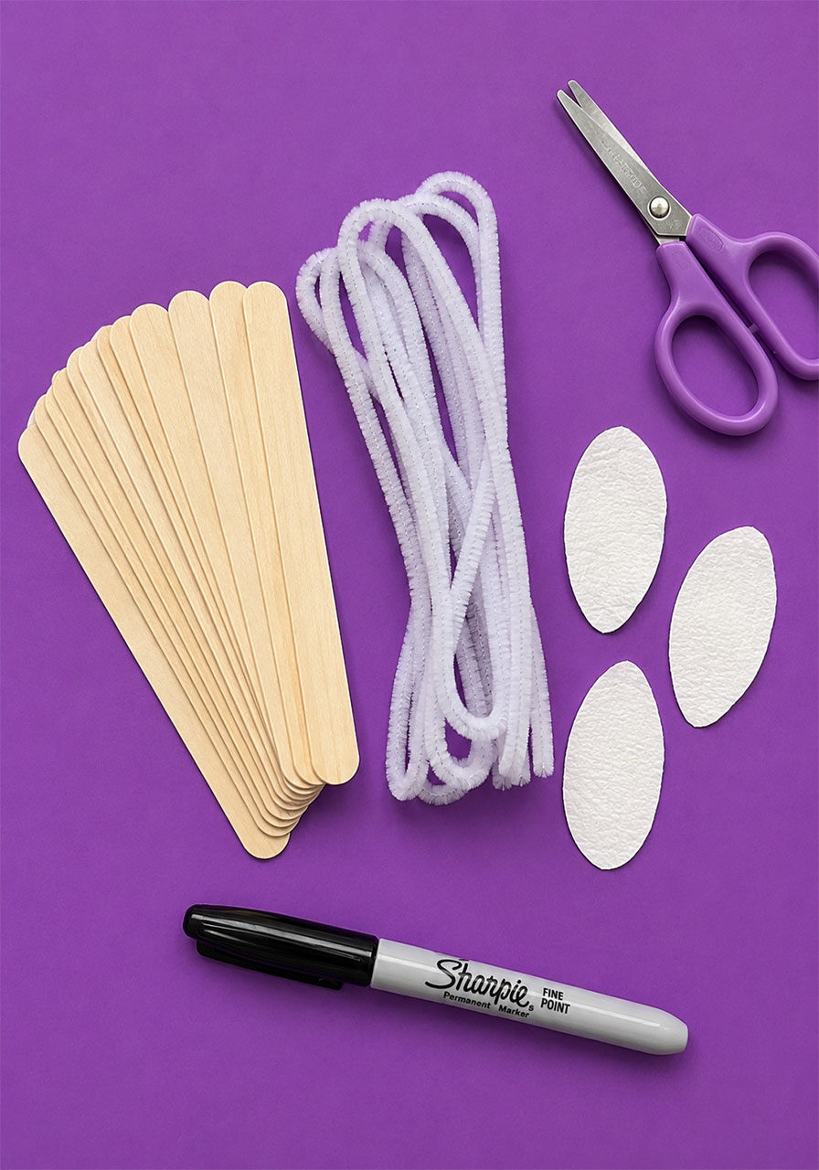 Craft sticks, pipe cleaners, and paper towel wings laid out as materials for a pollination STEM activity