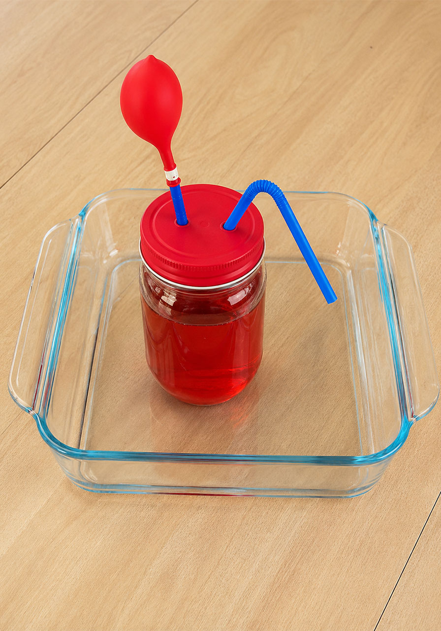 Pumping heart model jar set inside a tray to catch spills before the experiment begins