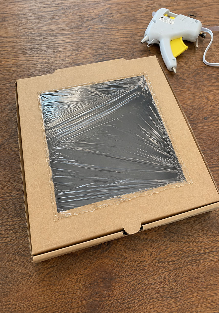 Plastic wrap sealed over a pizza box solar oven window
