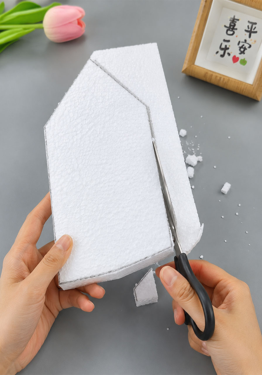 Cutting the house-shaped foam boat hull with scissors for the STEM Mini Picassos activity