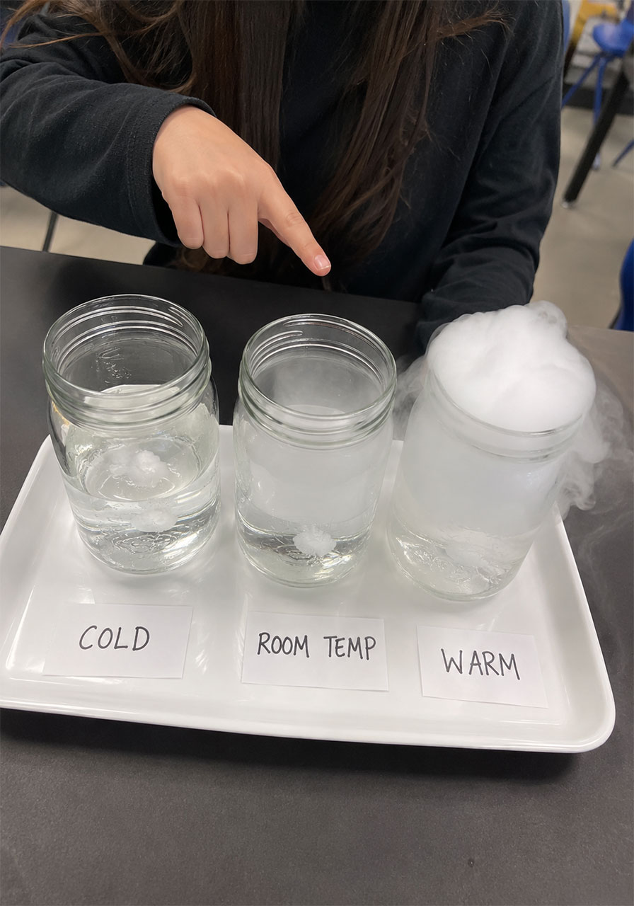 Three jars testing different water temperatures for a Halloween dry ice science experiment