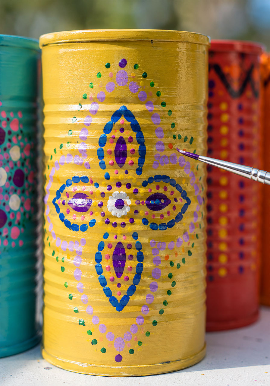 Hand-painted mandala dot pattern design on a tin can, a creative step in the STEM wind chime activity