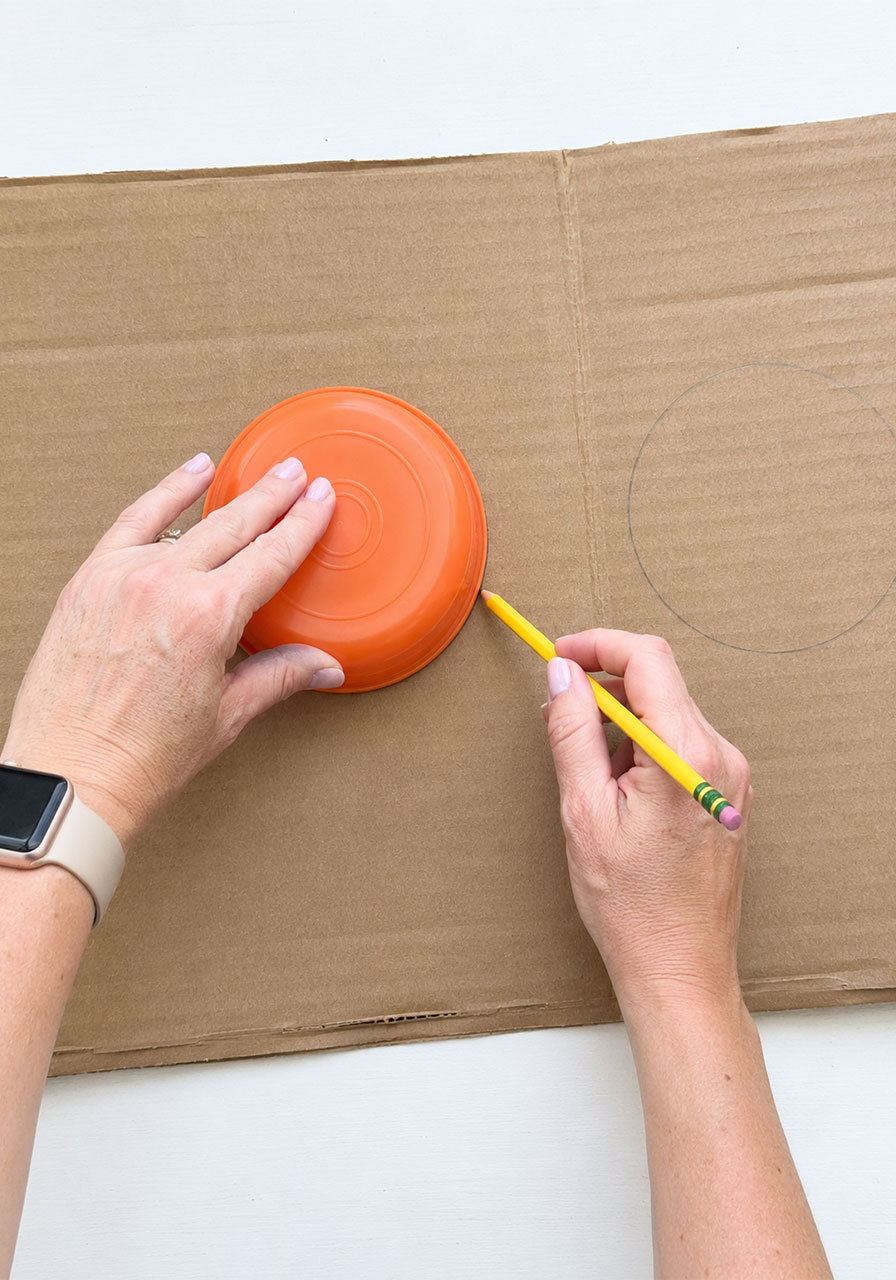 Tracing a bowl onto cardboard to cut circles for penny spinner base